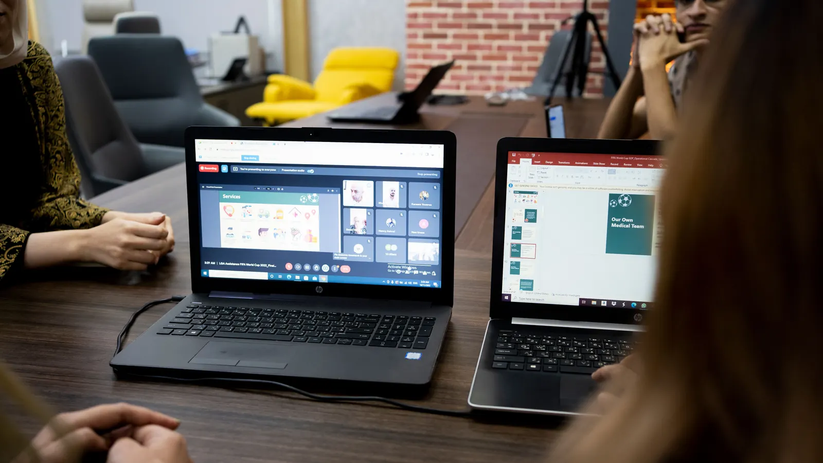 Colleagues reviewing figures on laptop screens together at a meeting table