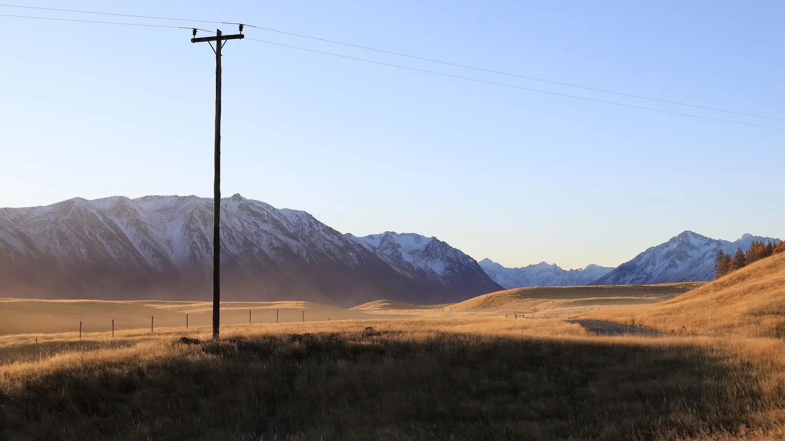 A power line crossing open farmland in rural New Zealand